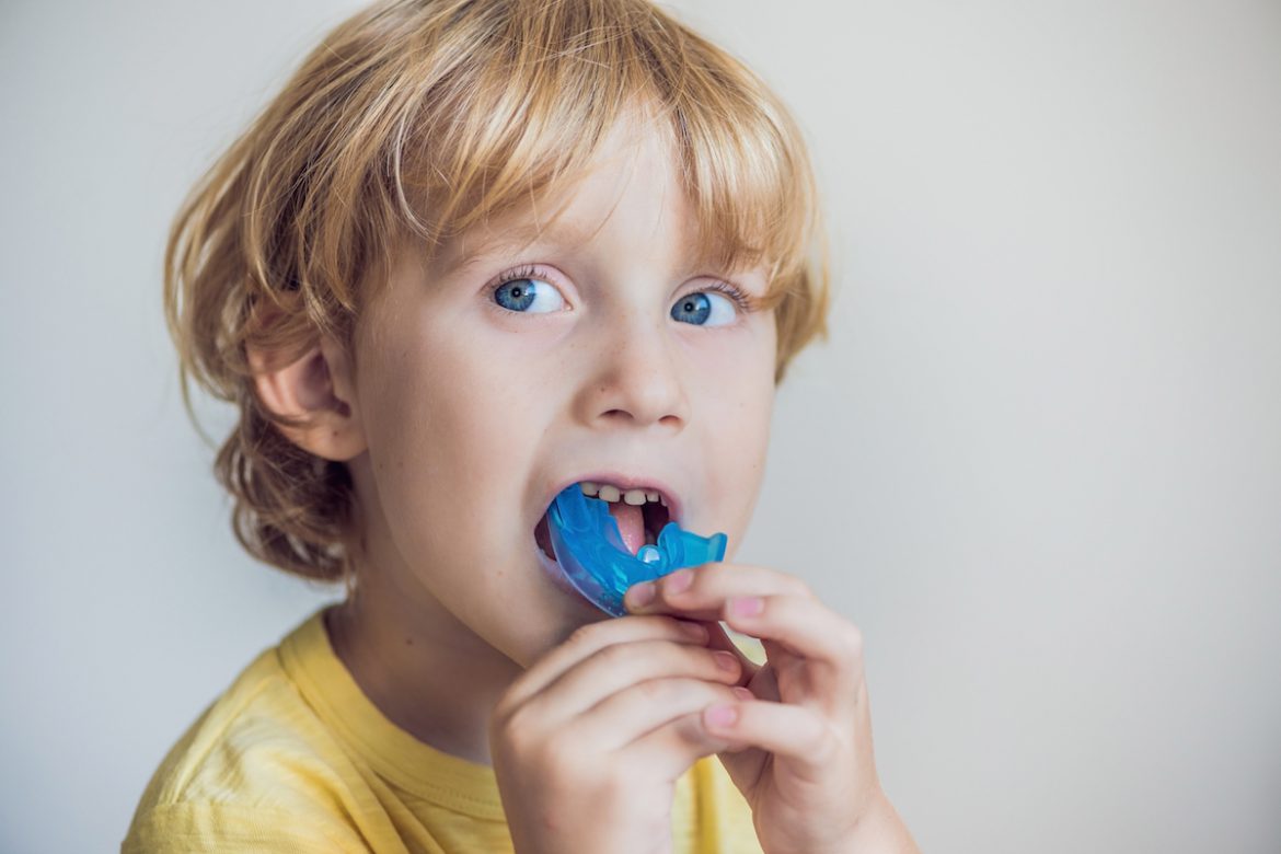 young boy putting in a mouthguard